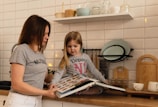 girl in gray crew neck t-shirt holding white tablet computer