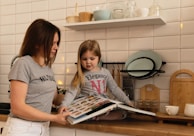 girl in gray crew neck t-shirt holding white tablet computer