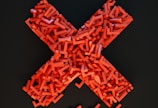 a cross made out of small pieces of red plastic