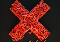 a cross made out of small pieces of red plastic