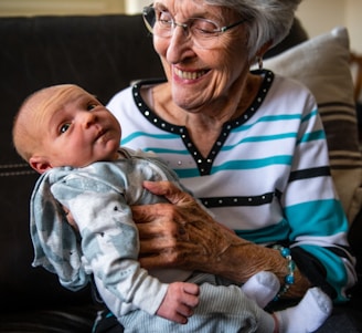 an older woman holding a baby