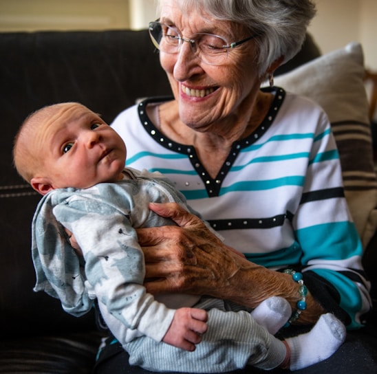an older woman holding a baby