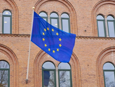 a european flag flying in front of a brick building