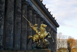 A statue of a man on a horse in front of a building